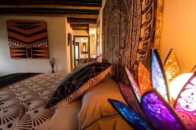 a bedroom with a bed with colorful pillows on it at Casa Rural zona Playa de Frejulfe in Piñera