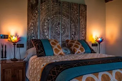 a bedroom with a bed with a large headboard at Casa Rural zona Playa de Frejulfe in Piñera