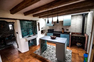 a large kitchen with blue cabinets and a counter top at Casa Rural zona Playa de Frejulfe in Piñera