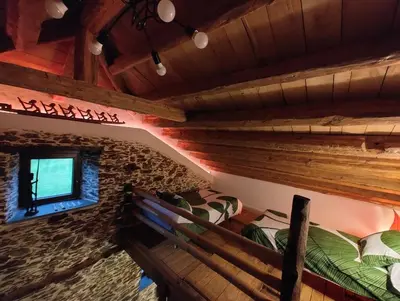 an attic room with two bunk beds and a window at Casa Rural zona Playa de Frejulfe in Piñera