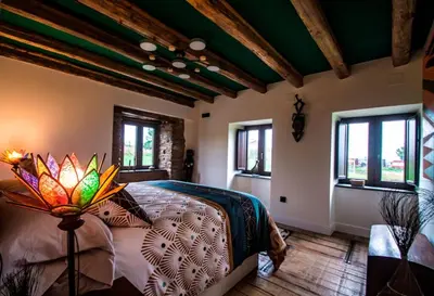 a bedroom with a bed in a room with windows at Casa Rural zona Playa de Frejulfe in Piñera