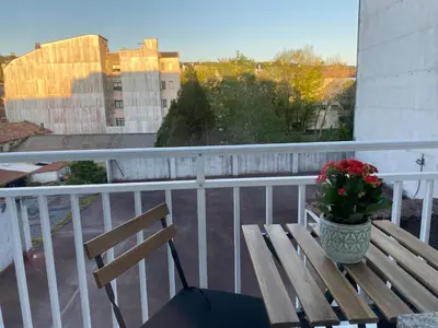 a wooden bench on a balcony with a vase of flowers at A tres Pasos in Caldas de Reis