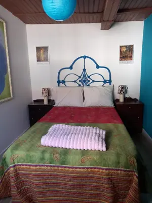 a bedroom with a large bed with a red and green blanket at A casa da Touza in Pensos