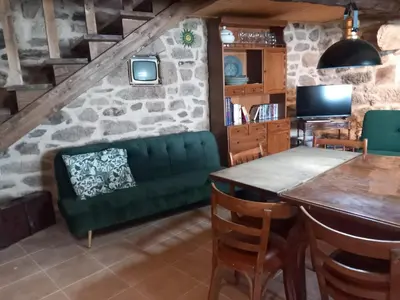 a living room with a green couch and a table at A casa da Touza in Pensos