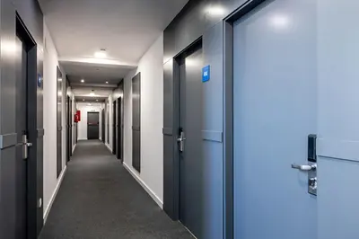 a corridor of elevators in an office building with blue doors at AS Hoteles Ponferrada in Columbrianos