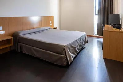 a bedroom with a bed and a television in it at AS Hoteles Ponferrada in Columbrianos