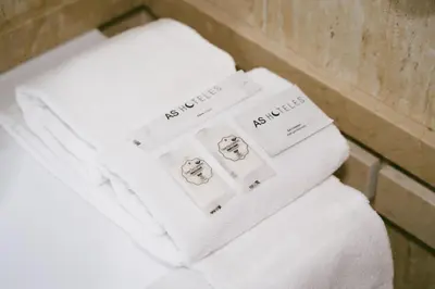 a pile of white towels sitting on top of a toilet at AS Hoteles Ponferrada in Columbrianos