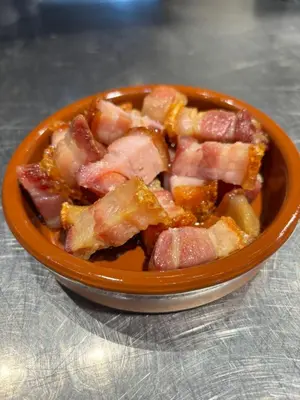 an orange bowl of food with bacon in it at AS Hoteles Ponferrada in Columbrianos