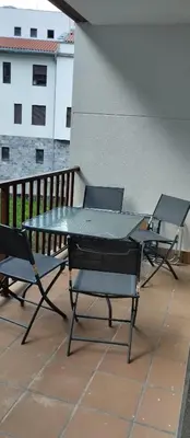 three chairs and a table on a balcony at La Vega De Somiedo 2 in Pola de Somiedo