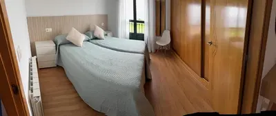 a bedroom with a bed with a green comforter at A Orillas de Llas in Foz