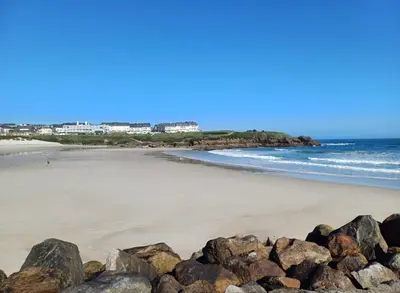 a beach with rocks in the sand and the ocean at A Orillas de Llas in Foz
