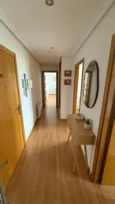 a hallway with a table and a mirror in a room at A Orillas de Llas in Foz