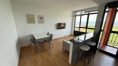 a living room with a table and chairs at A Orillas de Llas in Foz