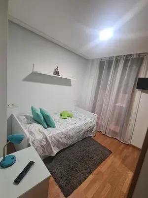 a white bedroom with a bed and a desk at Apartment in Costa with Spa, Jacuzzi in San Miguel de Reinante