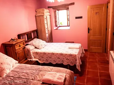 a bedroom with two beds and a window at Hotel Rural El Lagar De Las Médulas in Orellán