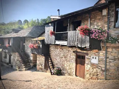an old stone building with flower boxes and a balcony at Hotel Rural El Lagar De Las Médulas in Orellán