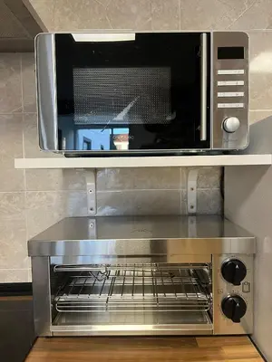 a microwave oven on a shelf in a kitchen at Albergue Freixo in Palas de Rei