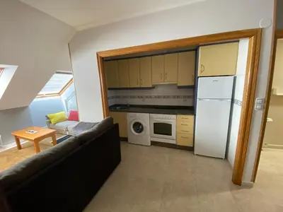 a living room with a couch and a kitchen at El Atico de Arriba in Viveiro