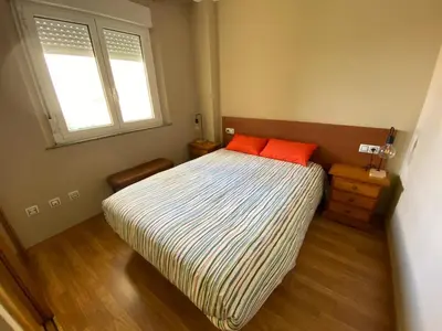 a bedroom with a bed with two orange pillows on it at El Atico de Arriba in Viveiro