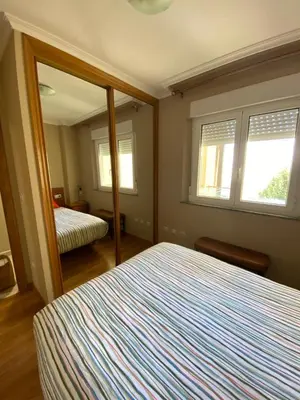 a bedroom with a large bed and a mirror at El Atico de Arriba in Viveiro