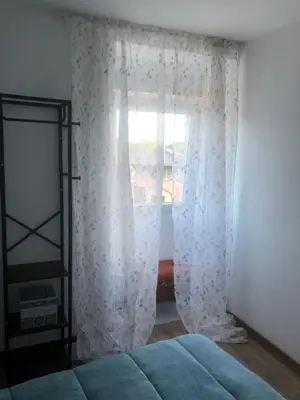 a bedroom with a bed and a window with curtains at A Castelana de Cea in Cea