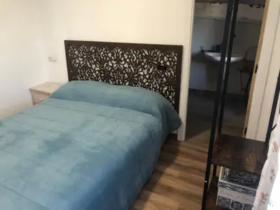 a bedroom with a bed and a mirror and a sink at A Castelana de Cea in Cea