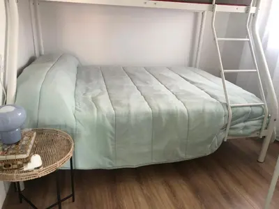 a bed with a green blanket in a room at A Castelana de Cea in Cea
