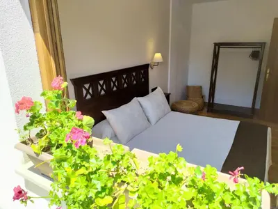 a bedroom with a bed and a couch and flowers at Camin de Muniellos apartamentos rurales in Cangas del Narcea