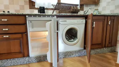 a washer and dryer in a kitchen at Camin de Muniellos apartamentos rurales in Cangas del Narcea