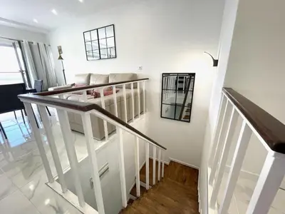 a living room with a staircase and a couch at housingcoruña BASTIAGUEIRO in Bastiagueiro