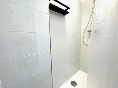 a white bathroom with a glass shower stall at housingcoruña BASTIAGUEIRO in Bastiagueiro