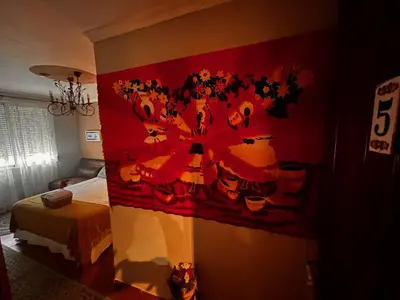 a bedroom with a painting on the wall at Hostal Casa San Nicolas in Molinaseca