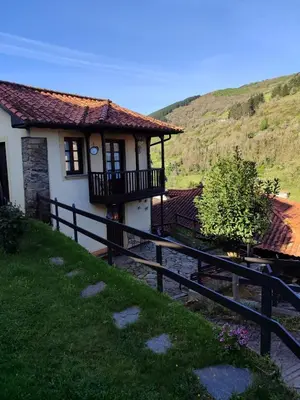 a house on a hill with a fence at La Casina de Santulaya in Adralés