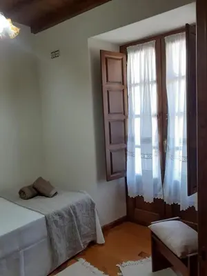 a white room with a bed and a window at La Casina de Santulaya in Adralés