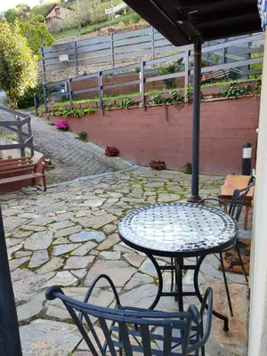 a table and chairs on a stone patio at La Casina de Santulaya in Adralés