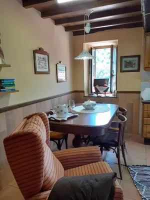 a living room with a dining room table and chairs at La Casina de Santulaya in Adralés