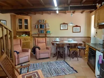 a kitchen with a table and chairs in a kitchen at La Casina de Santulaya in Adralés