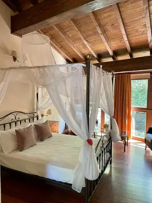 a bedroom with a canopy bed with white curtains at Couso Relax in Sarreaus