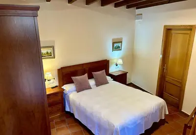 a bedroom with a white bed and two night stands at Couso Relax in Sarreaus