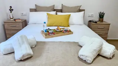 a bedroom with a bed with a tray of food on it at Apartamentos Pedras do Val in Mondariz