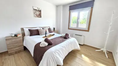 a bedroom with a large bed and a window at Apartamentos Pedras do Val in Mondariz