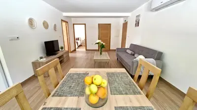 a living room with a table with a bowl of fruit at Apartamentos Pedras do Val in Mondariz