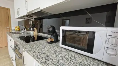a kitchen with a white microwave on a counter at Apartamentos Pedras do Val in Mondariz