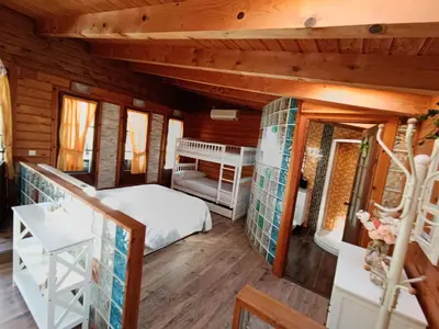 a bedroom in a log cabin with a bed at Finca el Filandón in San Miguel de Arganza