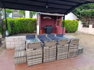 a table and chairs under a black canopy with a grill at Finca el Filandón in San Miguel de Arganza