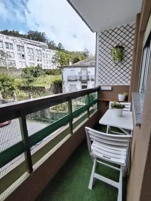 a balcony with a white table and a white chair at Lannion in Viveiro