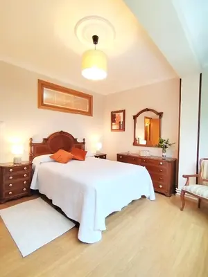 a bedroom with a large white bed and a mirror at Lannion in Viveiro