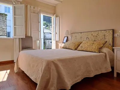 a bedroom with a large bed and a window at Casa Silandeira in Viveiro