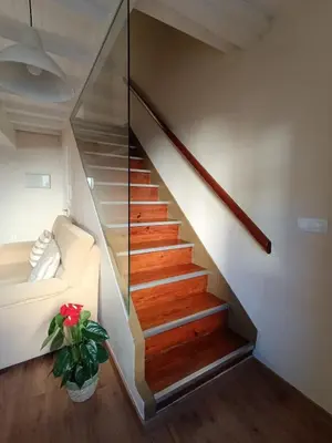 a stairway with a white couch and a glass wall at Casa Silandeira in Viveiro