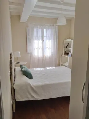 a bedroom with a white bed with a green pillow at Casa Silandeira in Viveiro
